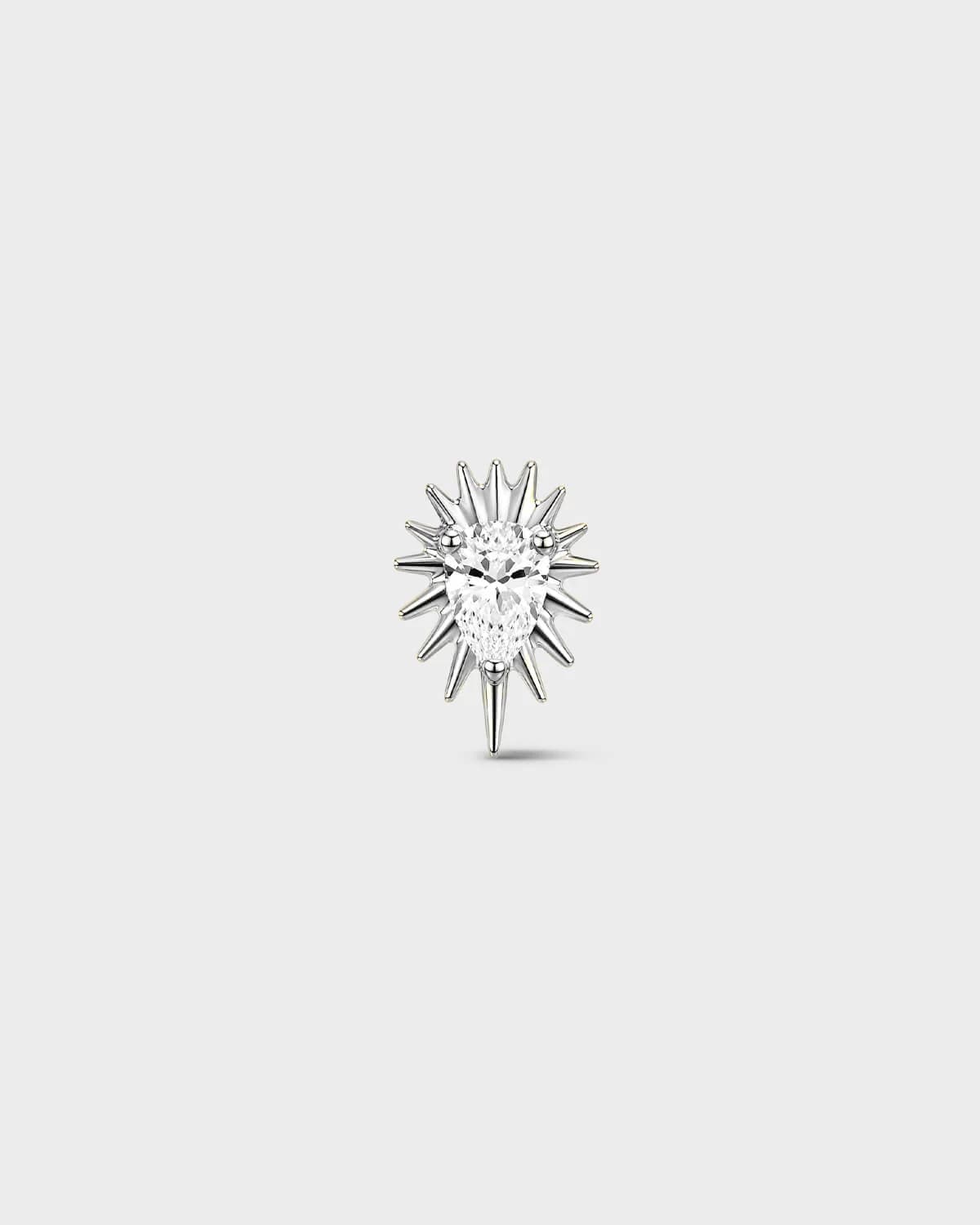 Polished silver titanium threadless end earring with a pear-cut clear stone set within a sculpted starburst design. On a light grey background.